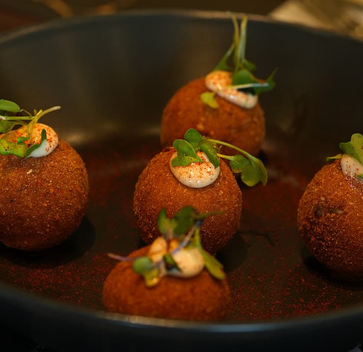 Croquetas de prosciutto con alioli de ajo negro