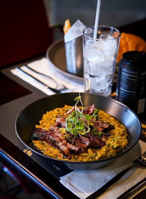 Risotto verde de espárragos con entraña asada encima
